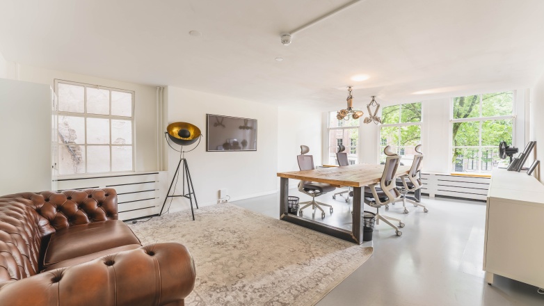 Straat met auto's en grachten langs de Herengracht 221 in Amsterdam