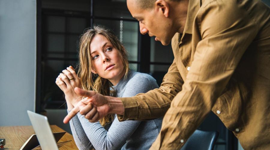 twee collega's discussieren over werk met een laptop